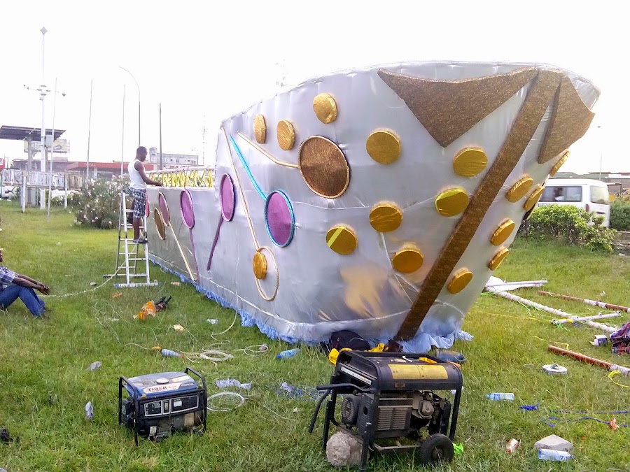 The White Ship, A silver hull with portholes and gold rivets lies on the grass, a generator and cables beside it.